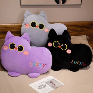 Cute plush cat pillows in purple, grey, and black with Lucky embroidery on a cozy bed