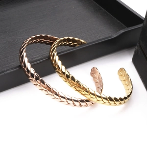 Macro view of gold and rose gold stainless steel bracelets with wheat ear texture