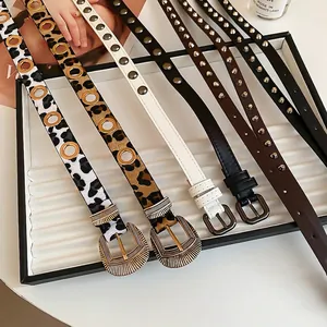 Ceintures à motif léopard et cloutées avec boucles vintage sur présentoir blanc élégant