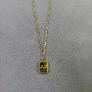 Detailed close-up of gold asymmetrical paperclip necklace with where is love pendant
