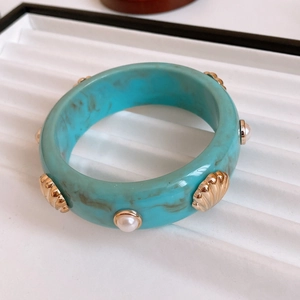 Detail of vintage turquoise marble resin bangle with gold shell and pearl studs