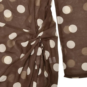 Gros plan sur tissu mousseline marron à pois avec détail de nœud et étiquette de taille S