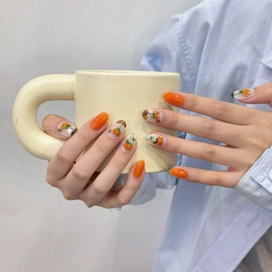 Faux ongles faits main orange avec motifs de tournesol et forme ovale élégante