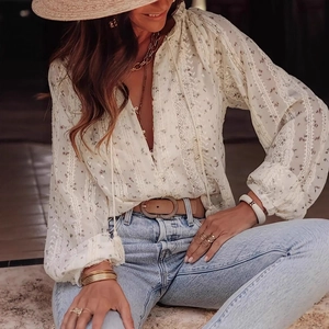 Detail of floral lantern sleeves and white lace hollow-out design on a bohemian blouse