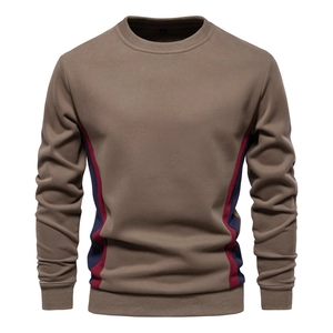Detail of men's crewneck sweatshirt featuring color block stitching on brown fabric