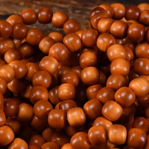 Macro detail showing smooth texture and warm orange tones of polished cedar wood beads