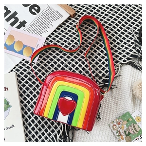 Close-up of heart patch and rainbow striped PU leather on the semi-circle crossbody bag