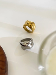 Detail of twisted wide band rings in gold and silver with a polished mirror finish