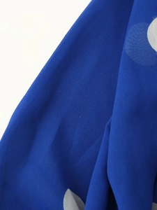 Gros plan sur le tissu mousseline bleu marine à pois montrant sa texture douce