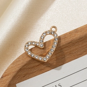Golden heart pendant with sparkling white rhinestones on a soft silk background
