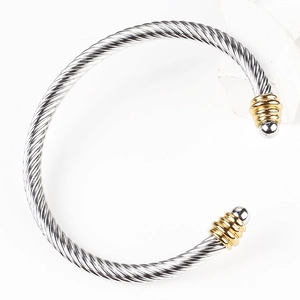 Detailed close-up of a silver cable twisted cuff bracelet with gold-tone screw end caps