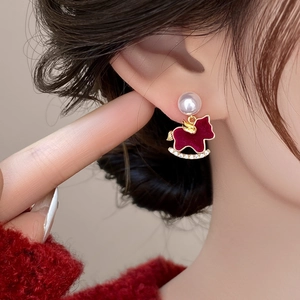 Detail of red flocked horse stud earring with white pearl and diamonds on model