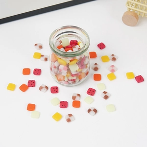 Miniature PVC fruit slices and resin candy charms for DIY crafts in a glass jar
