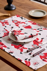 Detailed view of Santa Claus print cloth napkins and placemats on a rustic wooden table