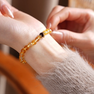 Detailed close-up of natural citrine and garnet beaded bracelet with golden floral accents
