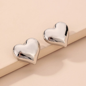 Gros plan de boucles d'oreilles cœur en argent avec une finition miroir hautement polie