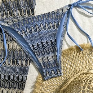 Détails en gros plan d'un bikini en crochet avec broderie bleue et texture tissée