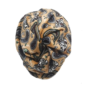 Detail of khaki paisley plush turban hat featuring a central twist knot design for women