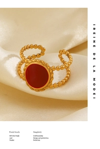 Detail of 18K gold-plated oval ring featuring red enamel inlay on silk background