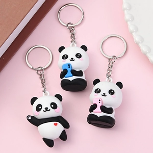 Set mit 3 niedlichen Panda-Schlüsselanhängern mit bunten Accessoires auf Rosa