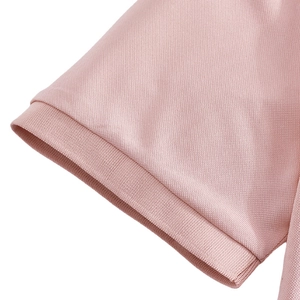 Macro detail of the pink polo shirt ribbed cuff and breathable piqué mesh fabric texture