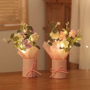 Handcrafted crochet flower bouquet in pink ceramic pot with warm LED string light detail