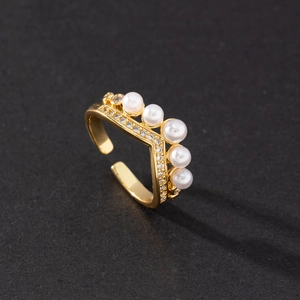Detailed macro view of gold crown ring featuring white pearls and micro-pave cubic zirconia