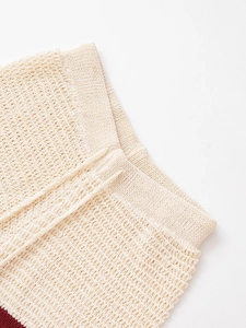 Detail van de crème gebreide short met opengewerkte haaktextuur en trekkoord in taille