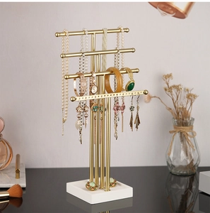 Detail of 4-tier golden jewelry stand with white base and earring organizer holes