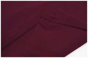 Close-up of double stitching and edge finish on burgundy outdoor sports trousers