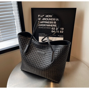 Close-up of the black woven texture and durable PU leather on the large tote bag