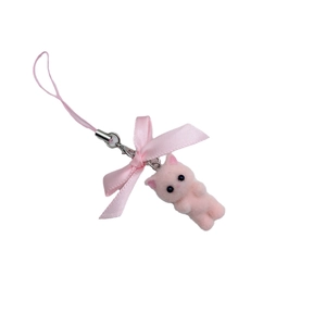 Pink flocked cat keychain with ribbon bow hanging on a minimalist white background