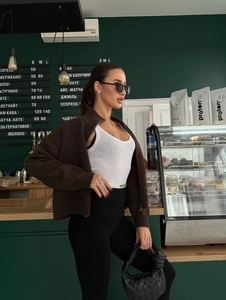 Detail der Strickstruktur einer braunen Strickjacke mit Reißverschluss im urbanen Stil
