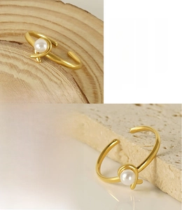 Macro detail of 18K gold plated stainless steel open ring featuring a white faux pearl