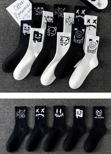 Detail view of cotton crew socks featuring black and white cartoon monster graffiti patterns