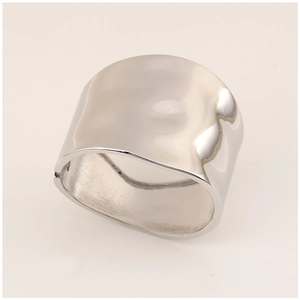 Macro detail of silver wide metal bangle showing textured hammer finish and mirror surface