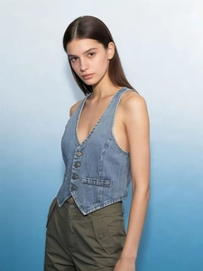 Detail shot of light blue denim vest for women with deep V-neck and metal buttons