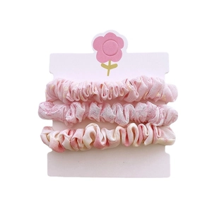 Lot de chouchous en tissu floral aux tons rose tendre sur carte de présentation