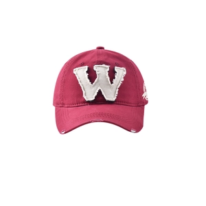 Détail d'une casquette vintage bordeaux en coton avec écusson W et bords effilochés usés