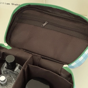 Interior view of large travel cosmetic bag with mesh zipper pocket and compartments