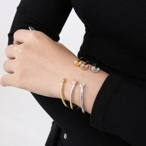 Three minimalist stainless steel open cuff bracelets in gold, rose gold and silver