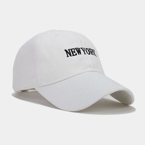 Dettaglio del ricamo nero NEW YORK su cappellino da baseball in cotone bianco