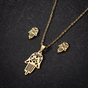 Golden Hamsa hand necklace and earrings jewelry set on a black sparkling background