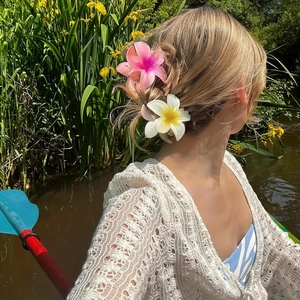 Realistic Plumeria hair claws in pink and yellow for elegant summer vacation hairstyles