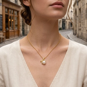 Detail of freshwater pearl necklace with gold bow pendant and diamonds on model