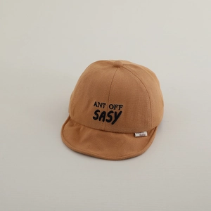 Detailed view of baby cotton cap featuring navy ANT OFF SASY letter embroidery