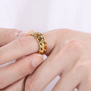 Close-up of golden Cuban chain style ring in titanium steel on a male model hand