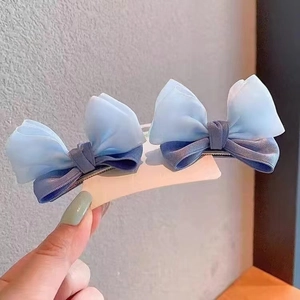 Detail of blue double-layered chiffon bow hair clips with satin finish and metal duckbill clip