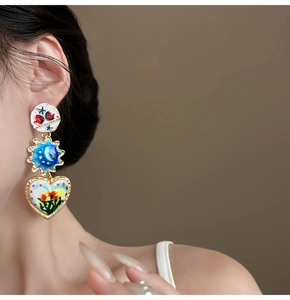 Detail of vintage enamel drop earring featuring a heart pendant with painted flowers