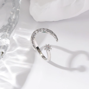 Close-up of adjustable silver moon and star open ring with sparkling zircon stones